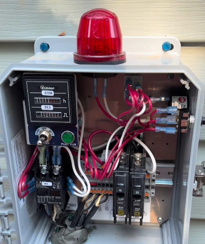 Septic control panel and alarm box installed on the exterior of a home